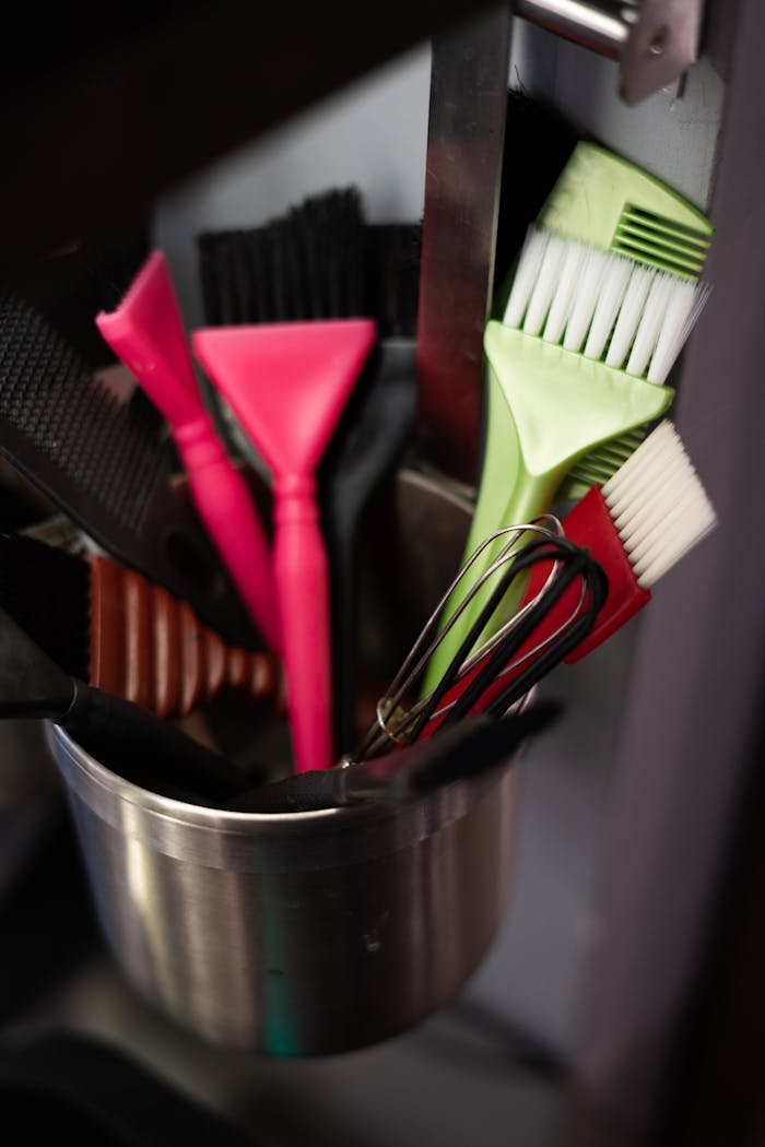 our-services-3 Vibrant brushes and tools in a metal pot at a salon vividly captured.